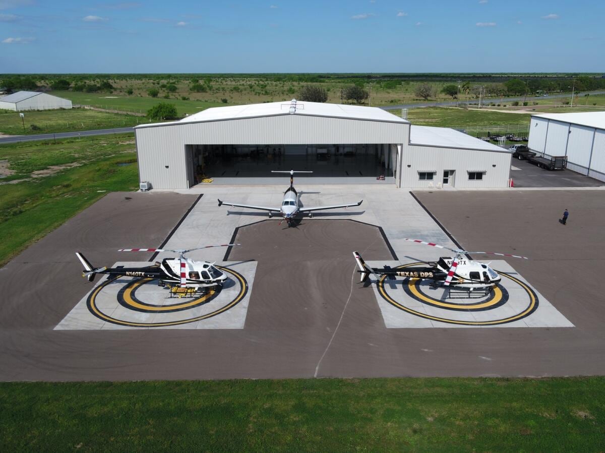 Aircraft and helicopters outside a hangar at South Texas International Airport