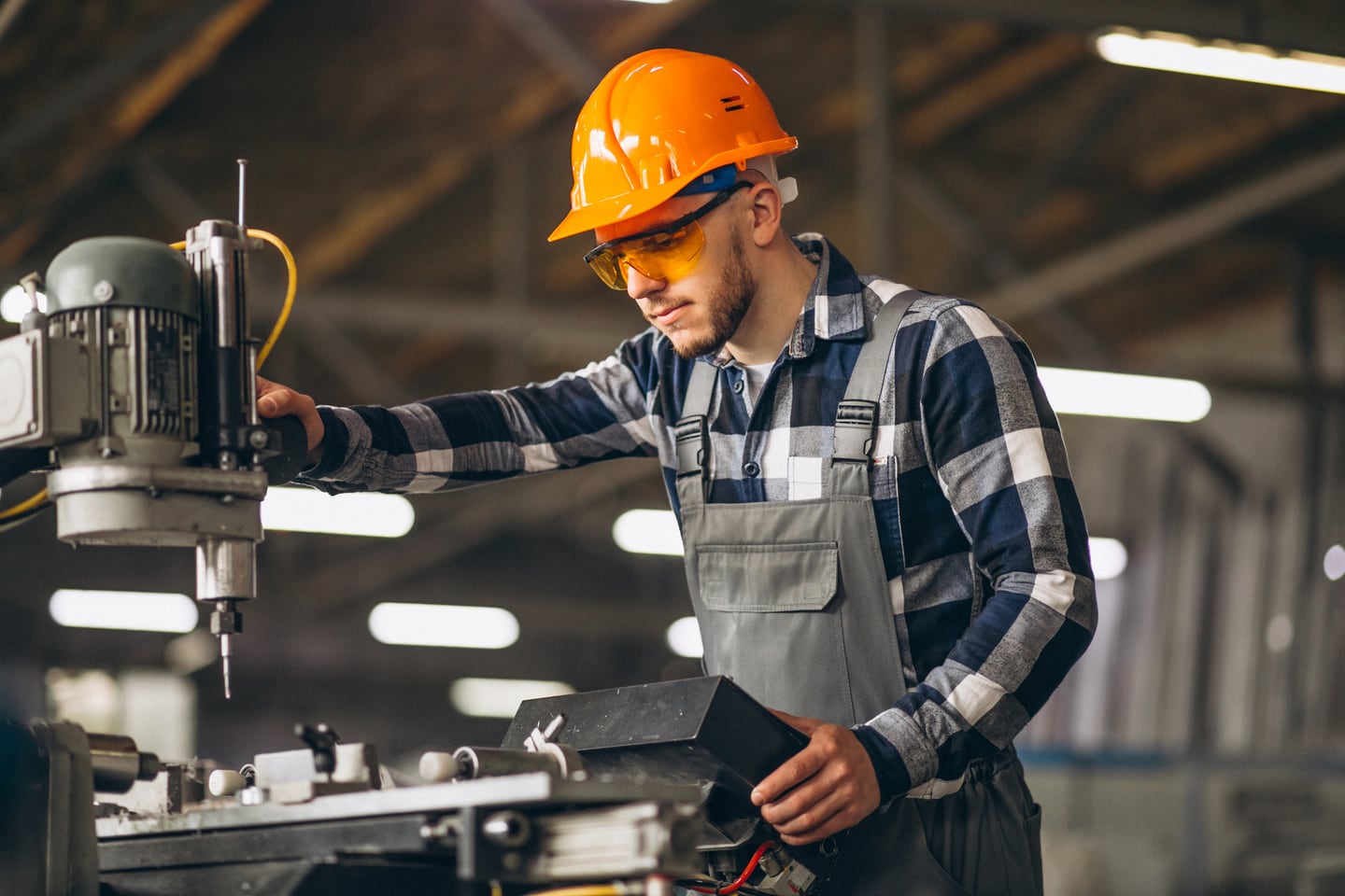 A machinist operating a drill press in Edinburg